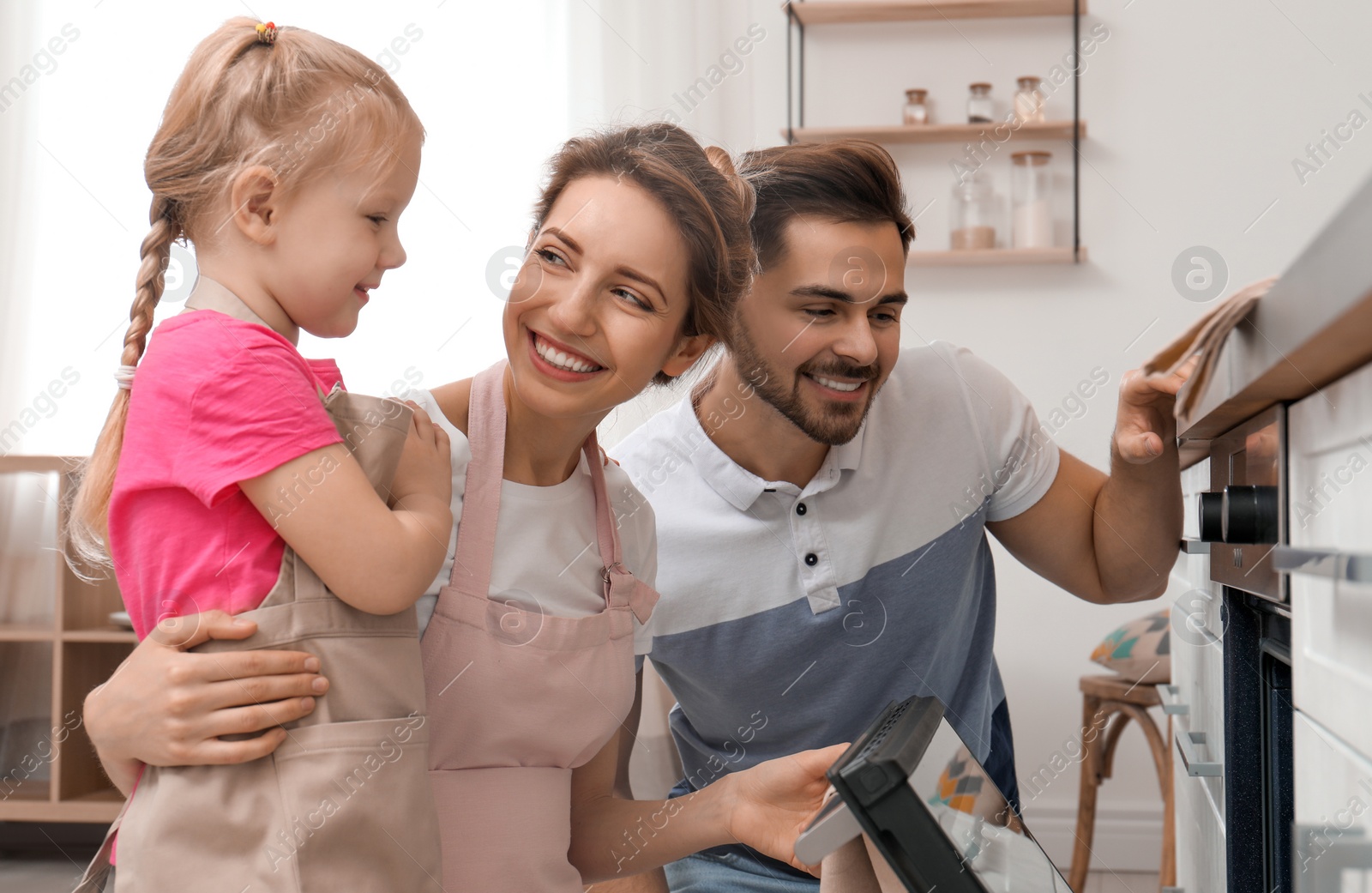 Photo of Happy family baking food in oven at home