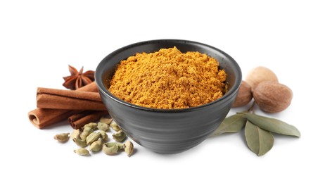 Dry curry powder in bowl and other spices isolated on white