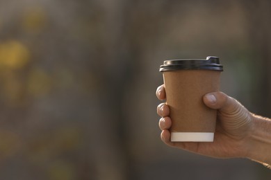 Photo of Man with takeaway coffee cup outdoors, closeup. Space for text