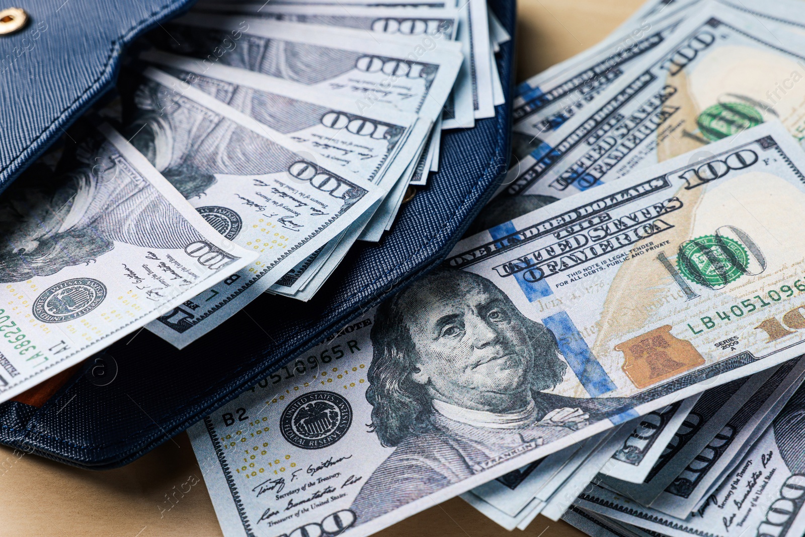 Photo of Dollar banknotes and wallet on wooden table, closeup. Money exchange