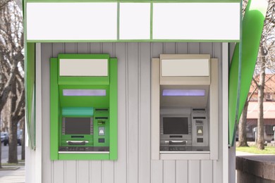 Photo of Modern automated cash machines with screens outdoors
