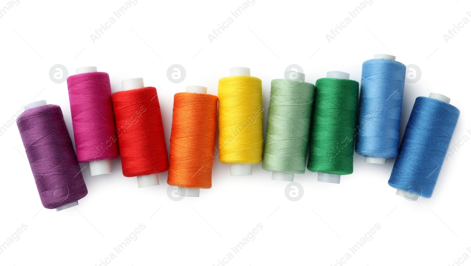 Photo of Set of different colorful sewing threads on white background, top view