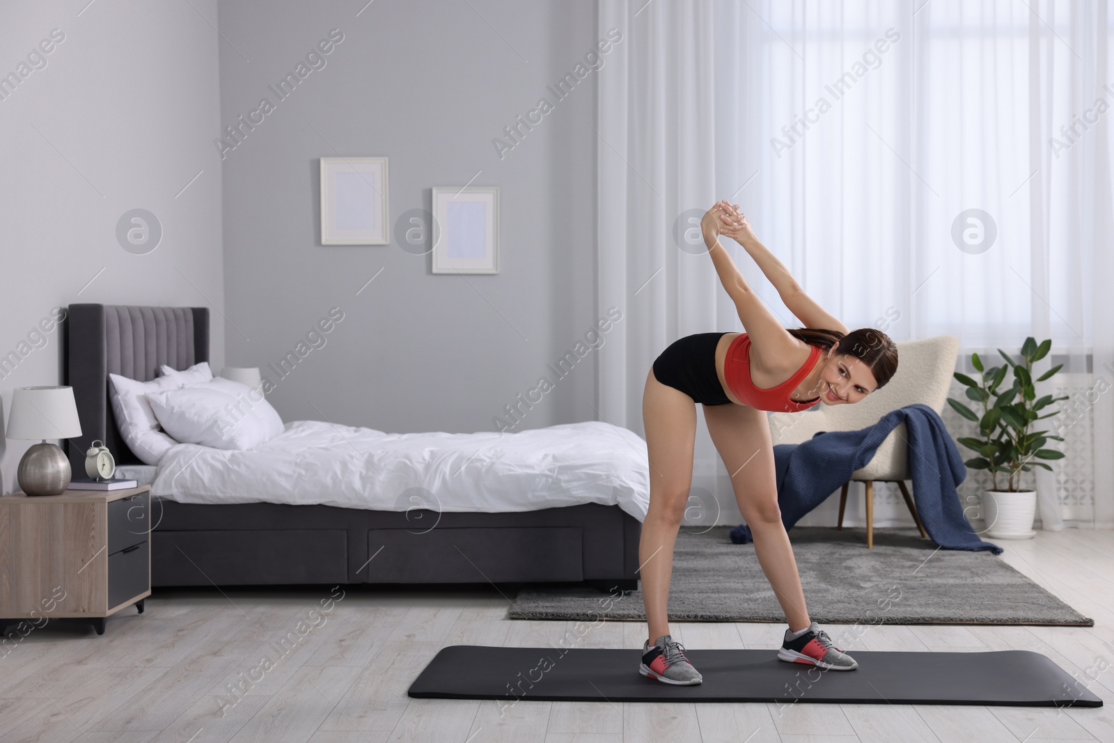 Photo of Morning routine. Happy woman stretching at home