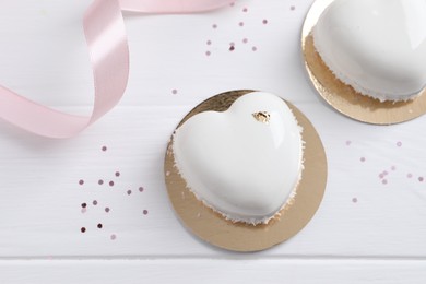 Photo of St. Valentine's Day. Delicious heart shaped cakes and confetti on white wooden table, flat lay