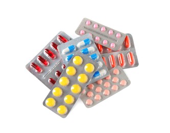 Blisters with different pills on white background, top view