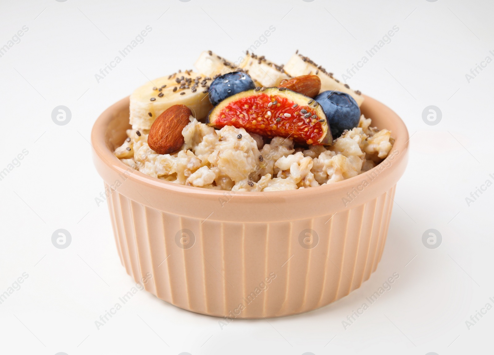 Photo of Bowl of oatmeal with blueberries, almonds, banana and fig pieces isolated on white