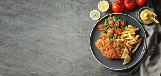 Image of Tasty schnitzels served on grey table, flat lay. Banner design with space for text