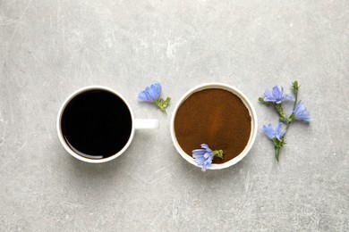 Photo of Cup of delicious chicory drink, powder and flowers on light grey table, flat lay