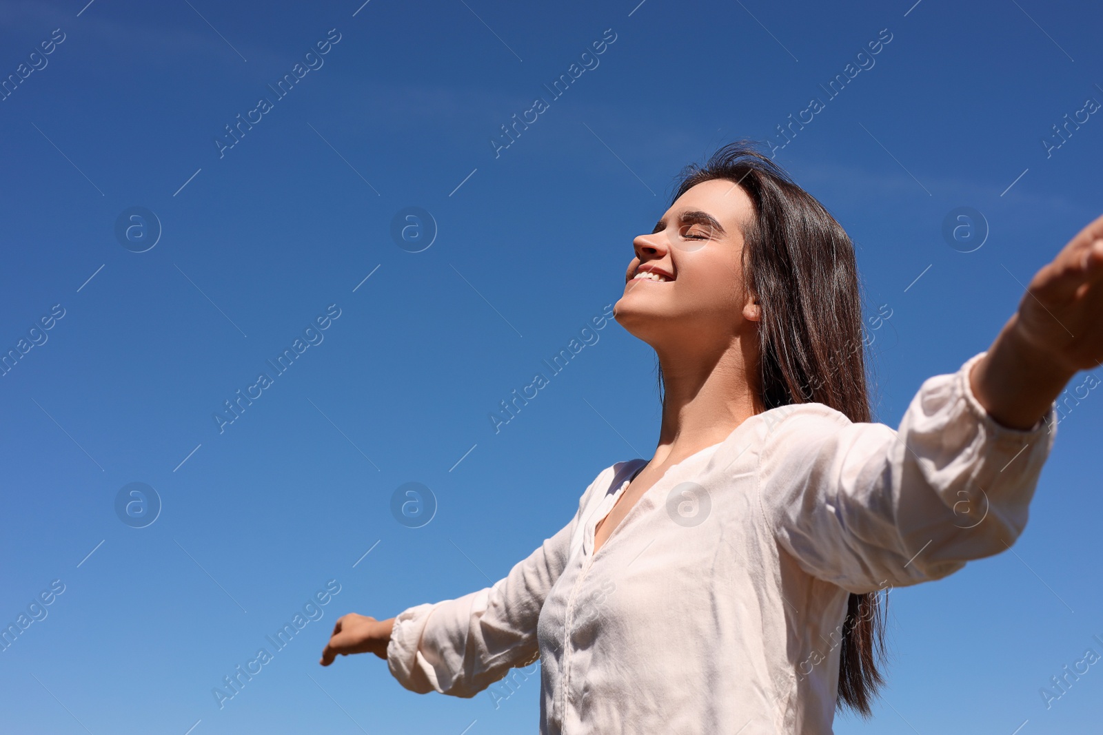 Photo of Portrait of beautiful young woman against blue sky. Space for text