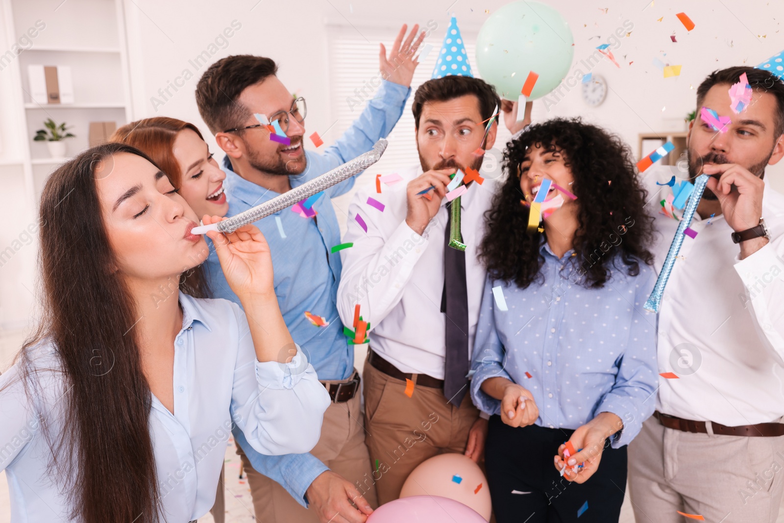 Photo of Coworkers having fun during office party indoors