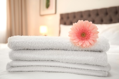 Photo of Flower on stack of fresh towels in hotel room