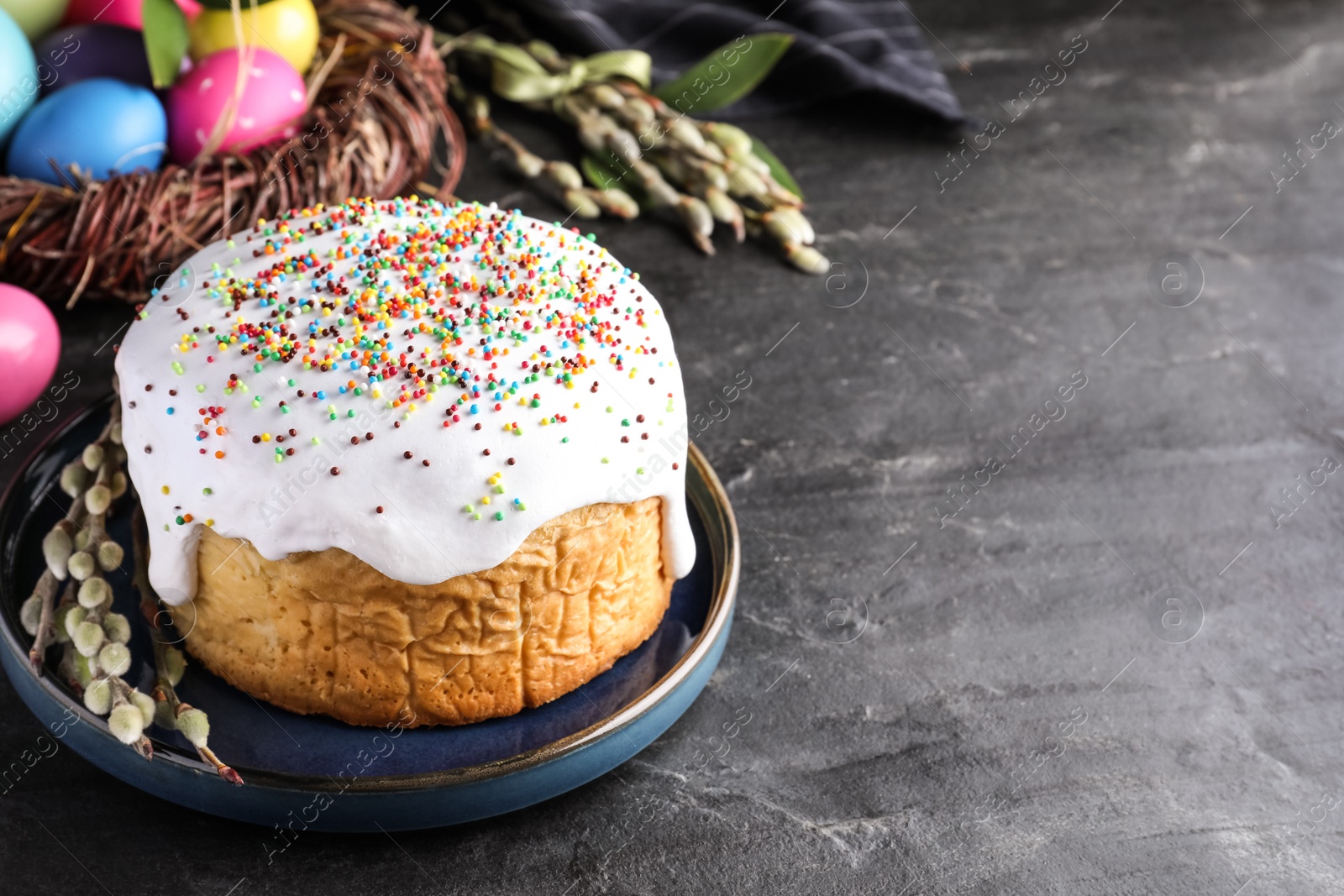 Photo of Traditional Easter cake and painted eggs on black table. Space for text