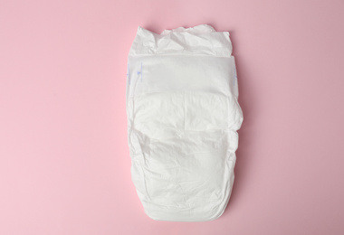 Photo of Baby diaper on pink background, top view