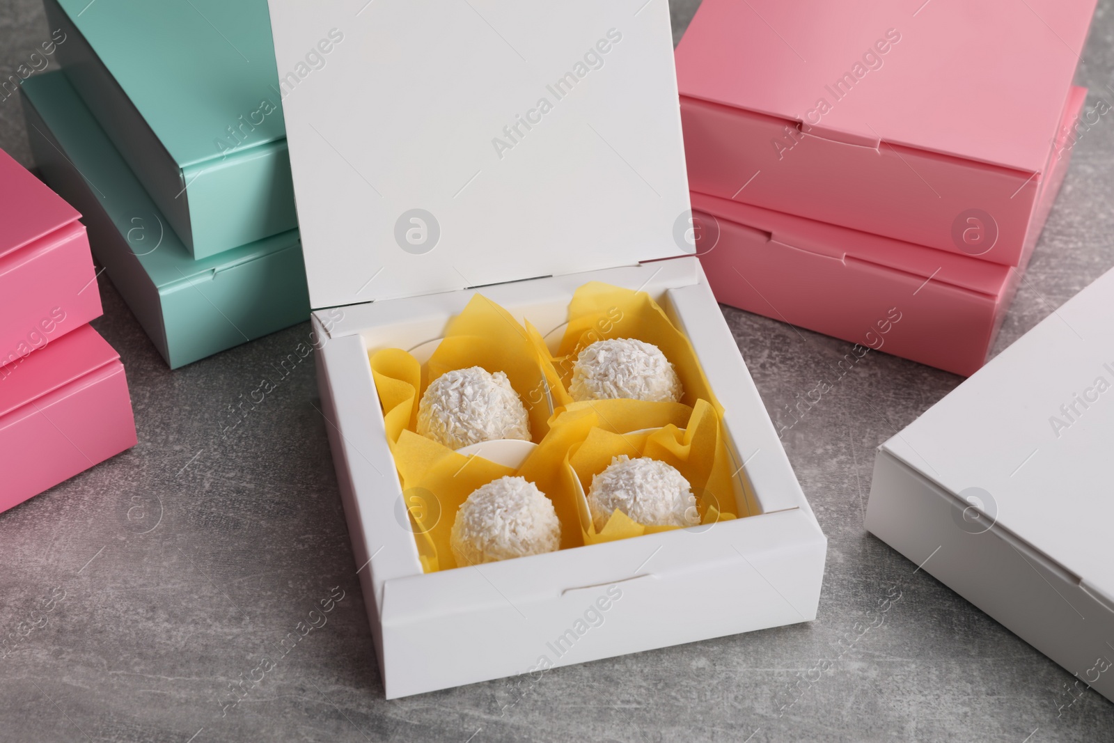 Photo of Delicious candies and box on light grey table. Production line