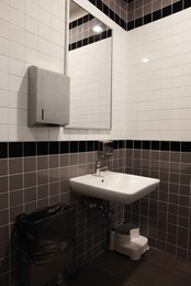 Public toilet interior with sink and mirror