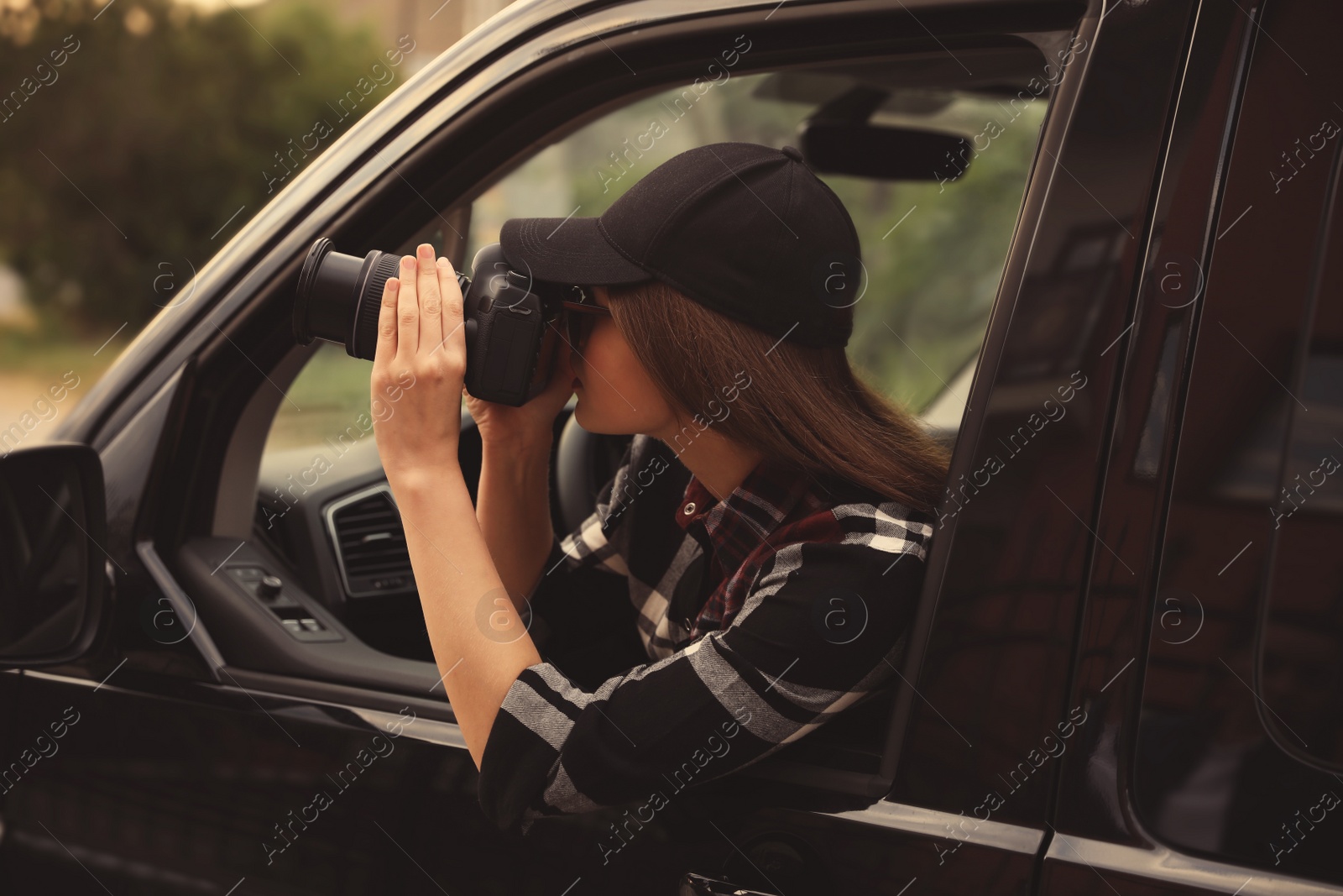 Photo of Private detective with camera spying from car