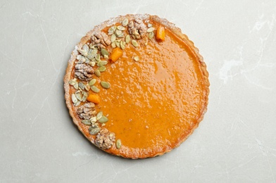 Delicious fresh homemade pumpkin pie on light grey marble table, top view