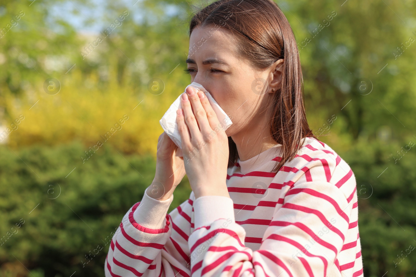 Photo of Woman with napkin suffering from seasonal allergy outdoors