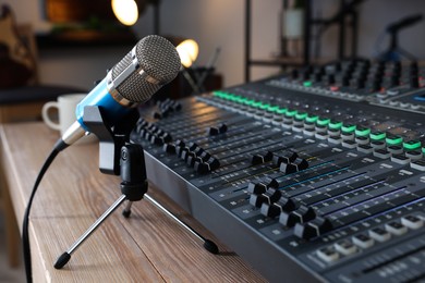 Microphone and professional mixing console on table in radio studio