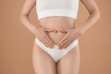 Photo of Gynecology. Woman in underwear on beige background, closeup