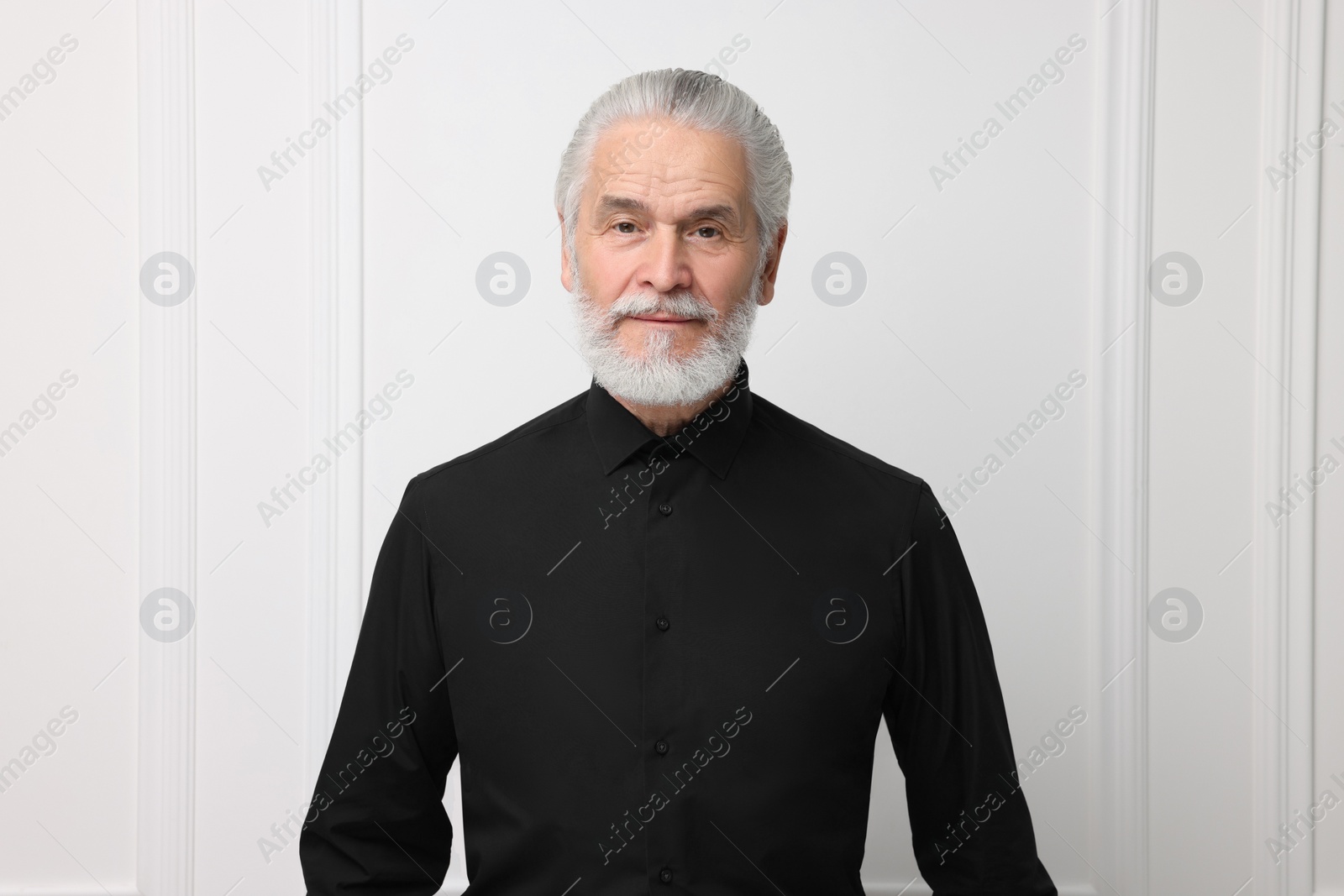 Photo of Portrait of handsome senior man near white wall