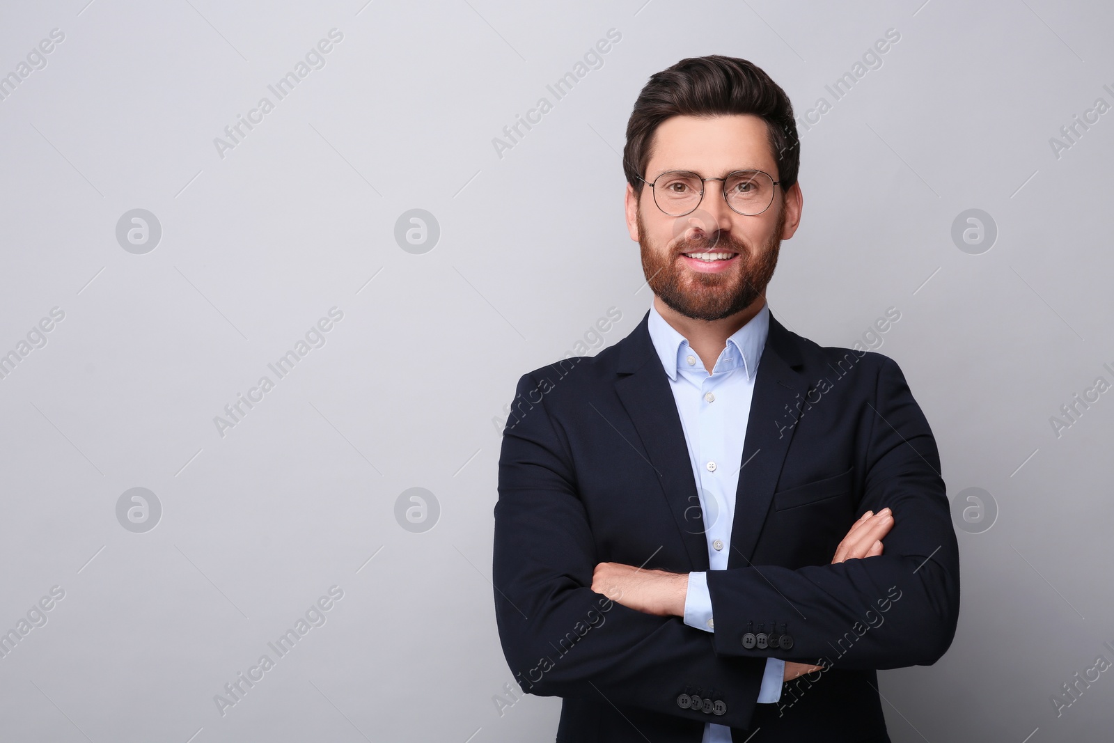 Photo of Portrait of handsome man in glasses on light grey background, space for text