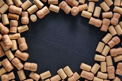 Photo of Frame made of wine bottle corks on black table, flat lay. Space for text