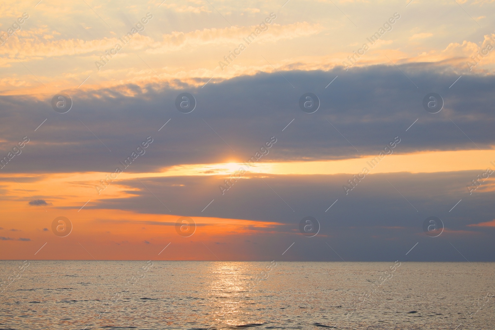 Photo of Picturesque view of sunset with beautiful clouds over sea