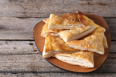 Photo of Delicious puff pastry with sesame seeds on wooden table
