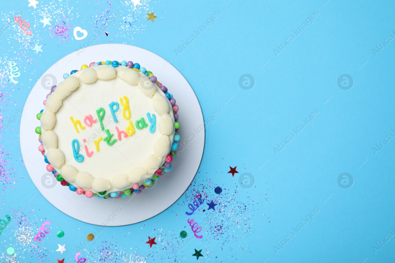 Photo of Cute bento cake with tasty cream and confetti on light blue background, flat lay. Space for text