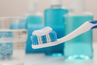 Photo of Brush with toothpaste on blurred background, closeup
