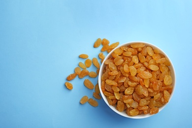 Photo of Bowl of raisins on color background, top view with space for text. Dried fruit as healthy snack