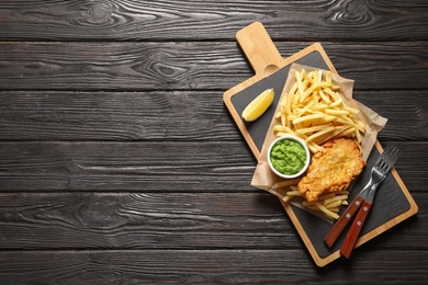 Photo of British Traditional Fish and potato chips on wooden background, top view. Space for text