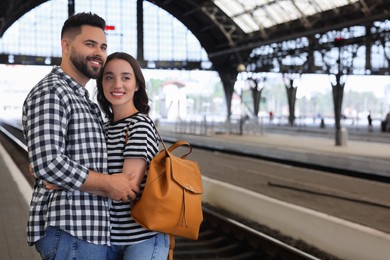 Long-distance relationship. Beautiful couple on platform of railway station, space for text