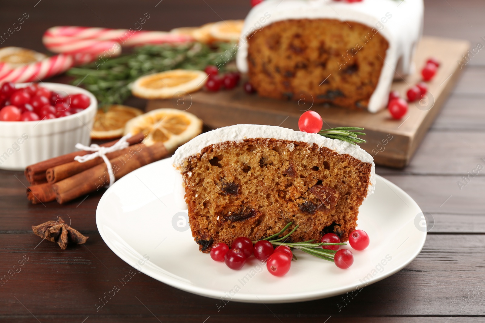 Photo of Traditional classic Christmas cake decorated with cranberries and rosemary on wooden table