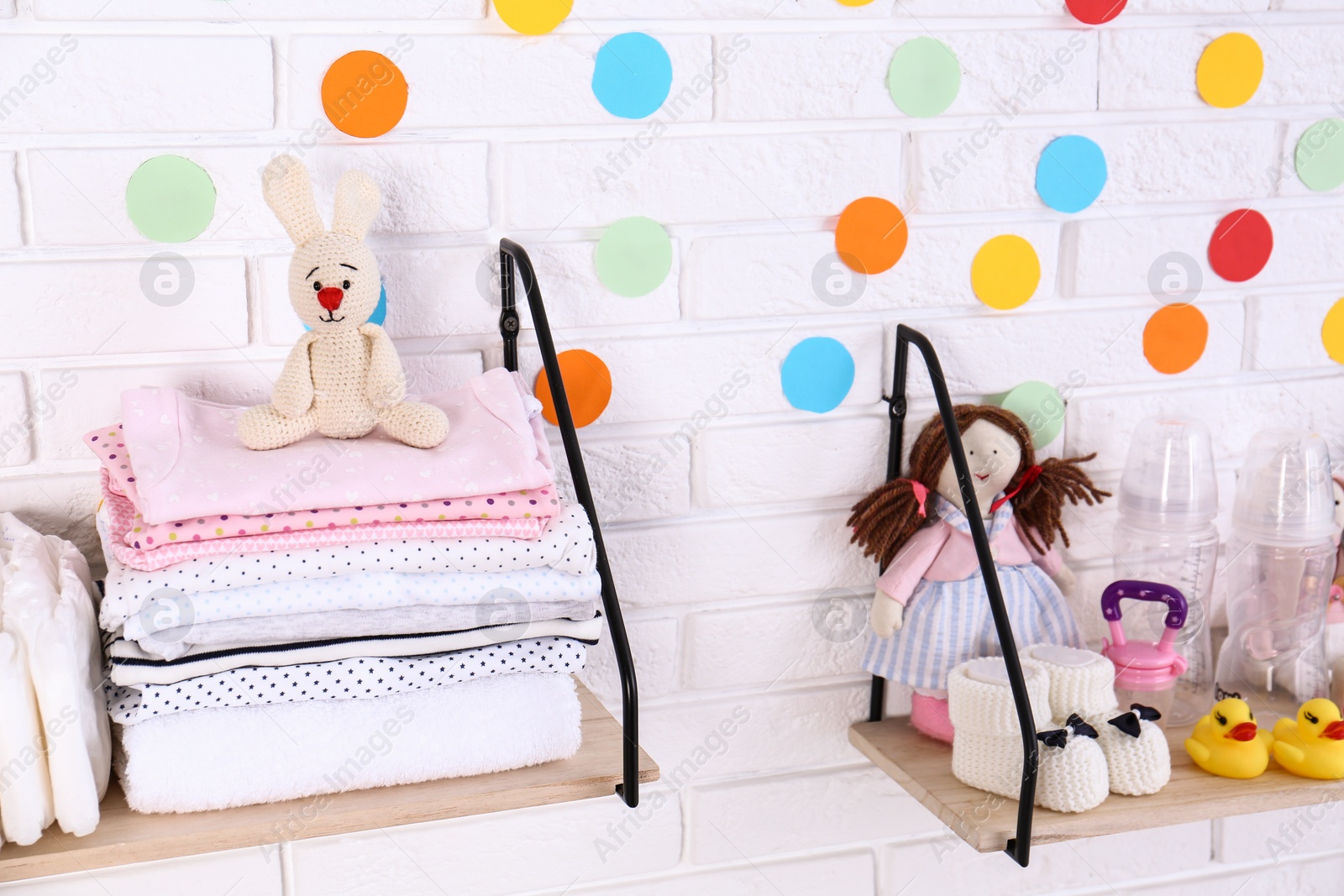 Photo of Baby accessories on shelves near white brick wall