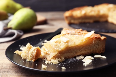 Photo of Piece of delicious sweet pear tart on table, closeup