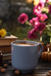 Photo of Cup of hot drink on wooden table outdoors, closeup. Cozy autumn