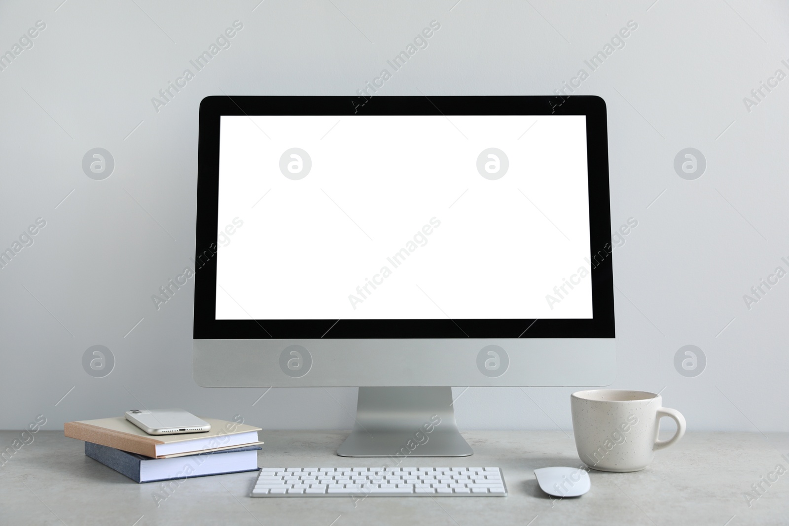 Photo of Modern computer with blank screen on light grey table. Mockup for design
