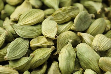 Photo of Dry green cardamom pods as background, closeup