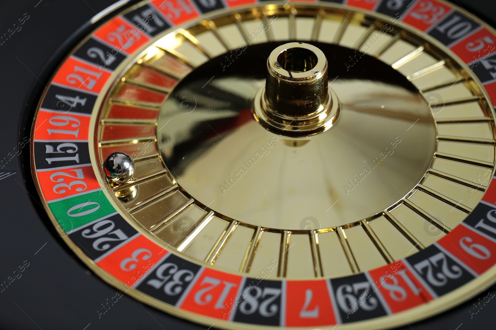 Photo of Roulette wheel with ball, closeup. Casino game