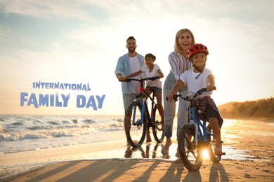 Image of Happy parents teaching children to ride bicycles on sandy beach near sea at sunset. Happy Family Day