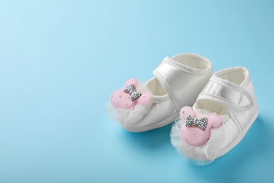 Photo of Pair of cute baby sandals on color background