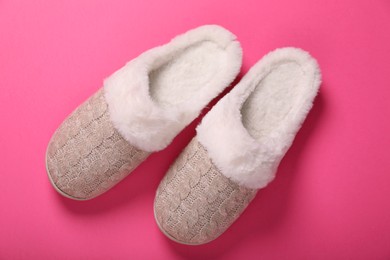 Photo of Pair of beautiful soft slippers on pink background, top view