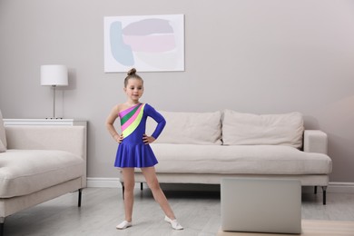 Cute little girl taking online dance class at home