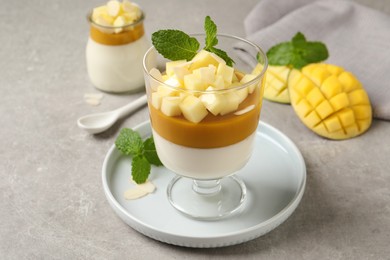 Photo of Delicious panna cotta with mango on grey table