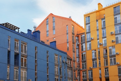 Photo of Colorful modern buildings with windows against sky. Urban architecture