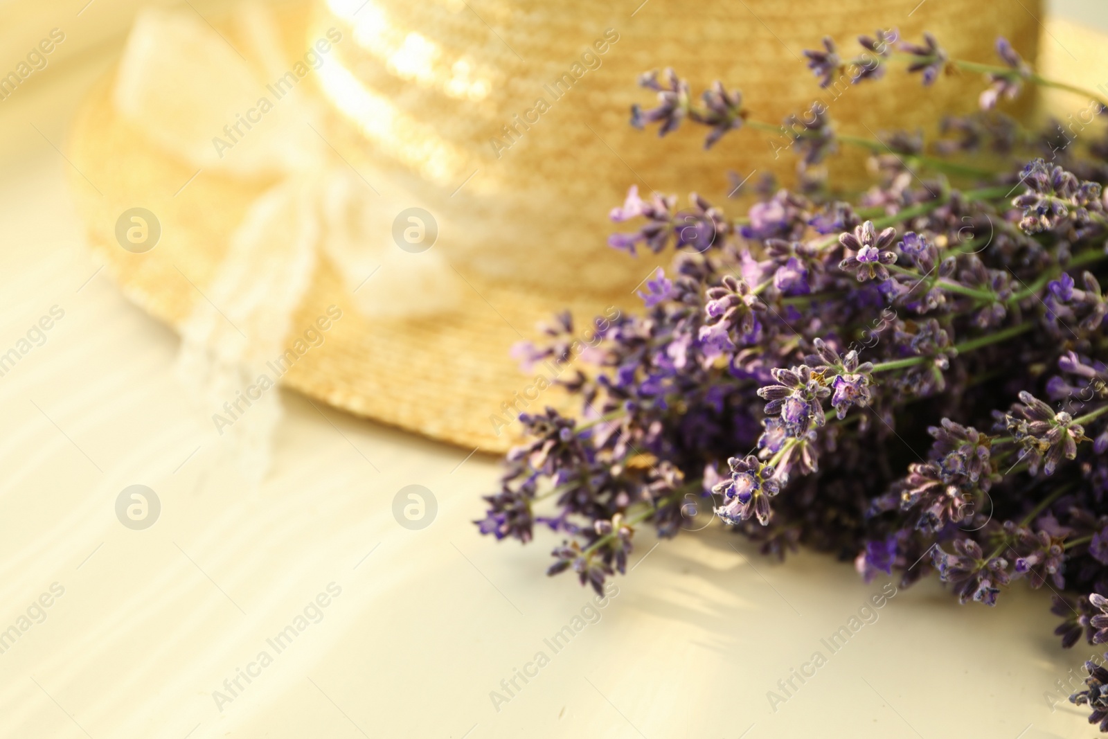 Photo of Beautiful lavender flowers and straw hat on window sill, closeup