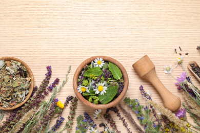 Photo of Flat lay composition with healing herbs on wooden table