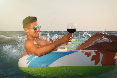 Photo of Man with glass of wine and inflatable ring resting in sea